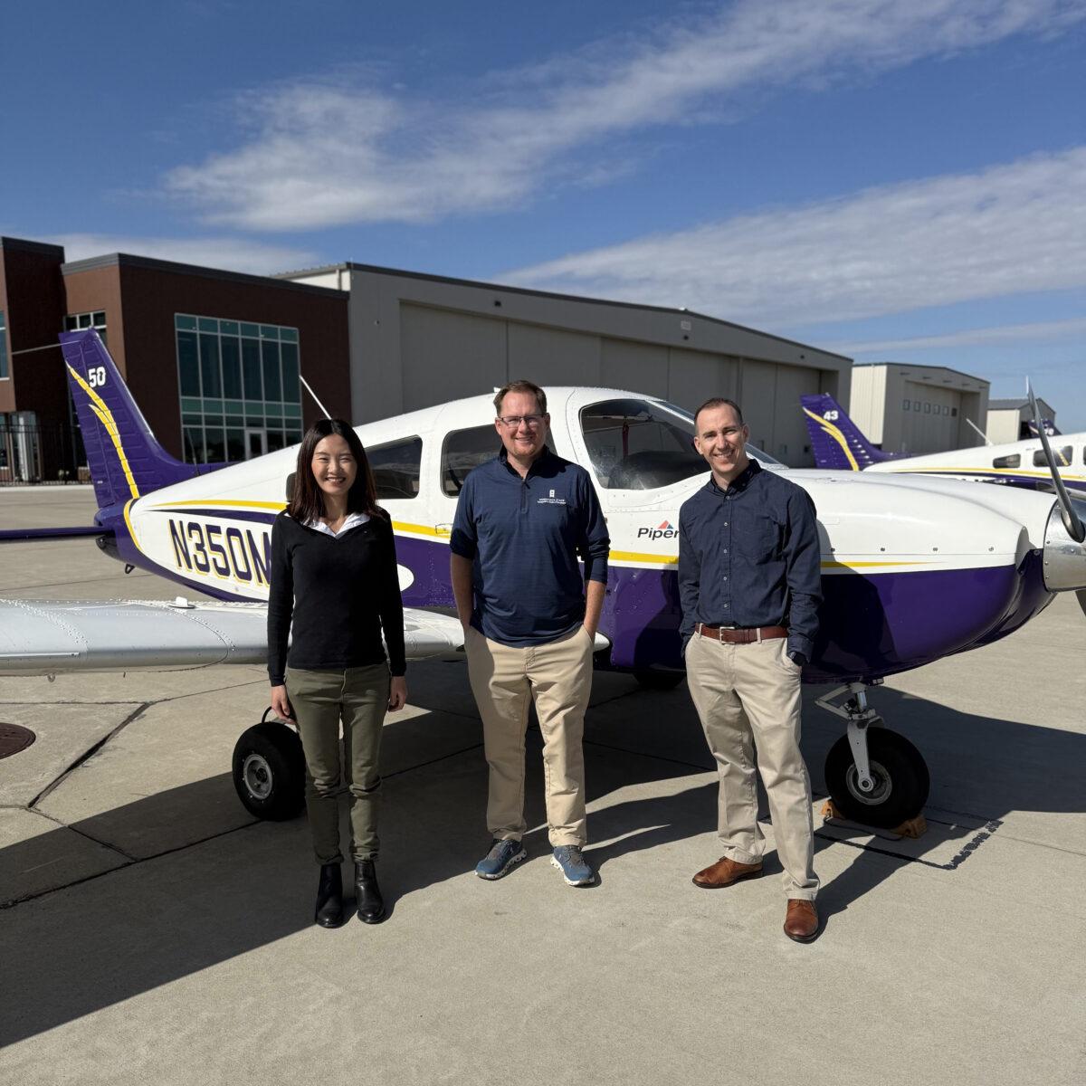 3 people standing in front of a white air plane